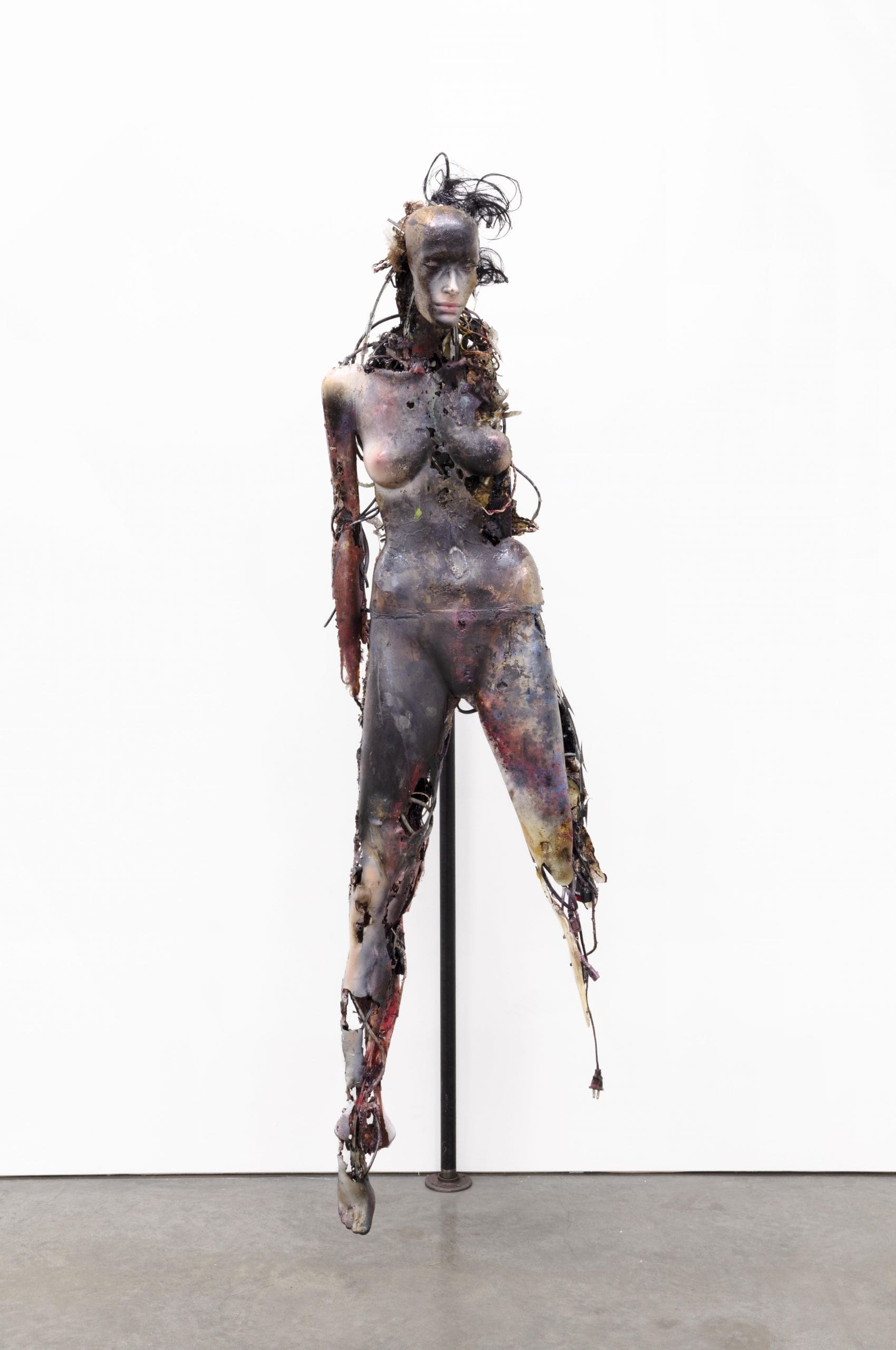 Stewart Uoo, Don't Touch Me (Unidentified Figure I), 2018, polyurethane and urethane resin, epoxy, ink, pigment, acrylic paint, ferrofluid, wires, cables, CDRs, DVDs, video cassettes, mobile phone screens, electronics, clothing, accessories, acrylic nails, steel, razor wire, stainless steel barbells, synthetic hair, synthetic eyelashes, glitter, flies, maggot cocoons, dust, 82 × 28 × 26 inches (208.28 × 71.12 × 66.04 cm)