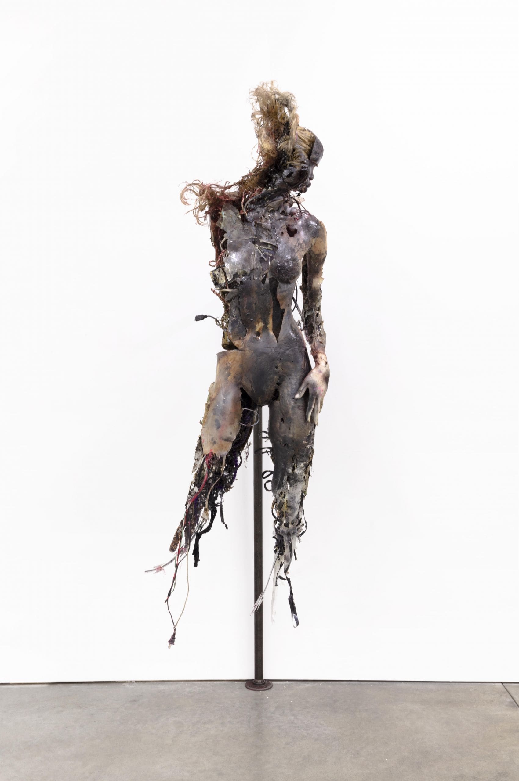 Stewart Uoo, Don't Touch Me (Unidentified Figure II), 2018, polyurethane and urethane resin, epoxy, ink, pigment, acrylic paint, ferrofluid, wires, cables, clothing, accessories, acrylic nails, steel, razor wire, stainless steel barbells, synthetic hair, synthetic eyelashes, glitter, flies, maggot cocoons, dust, 82 × 28 × 26 inches (208.28 × 71.12 × 66.04 cm)